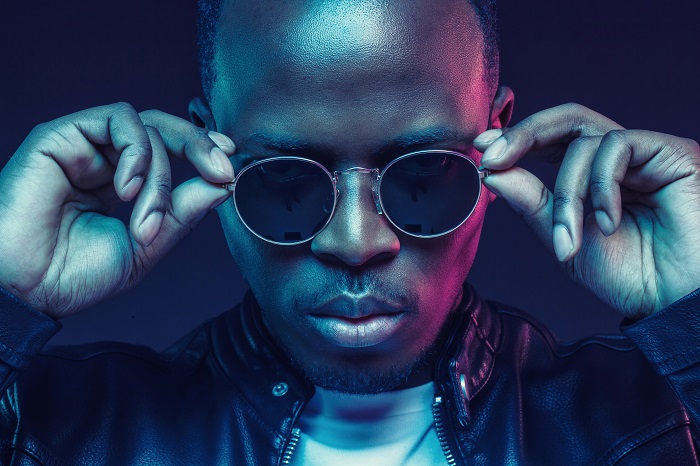 Close-up studio shot of african american male model wearing trendy sunglasses and leather jacket